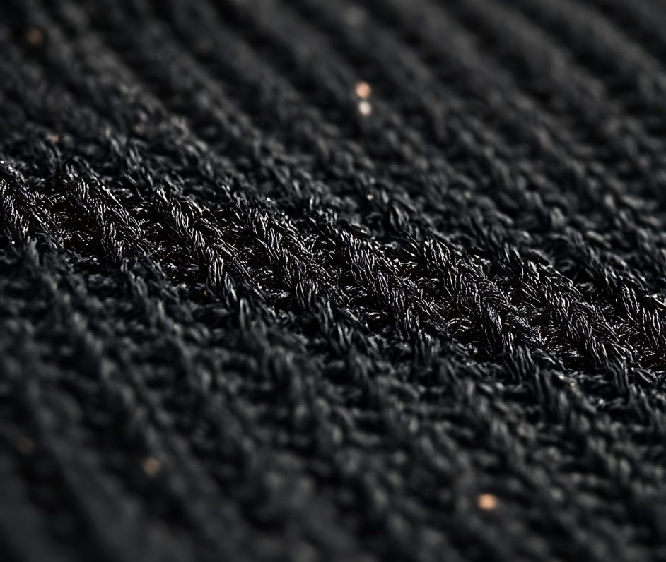 Close-up of textured black fabric with subtle shine.